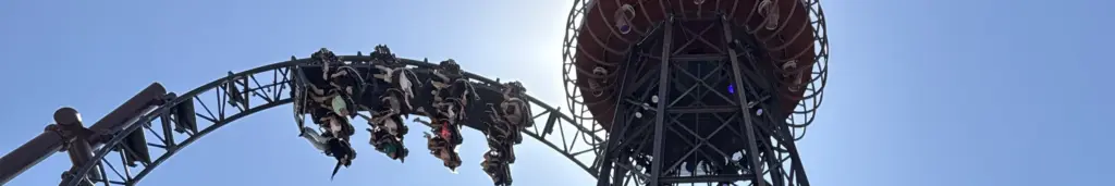 El loop de Voltron Nevera con un tren pasando y la torre de la atracción detrás